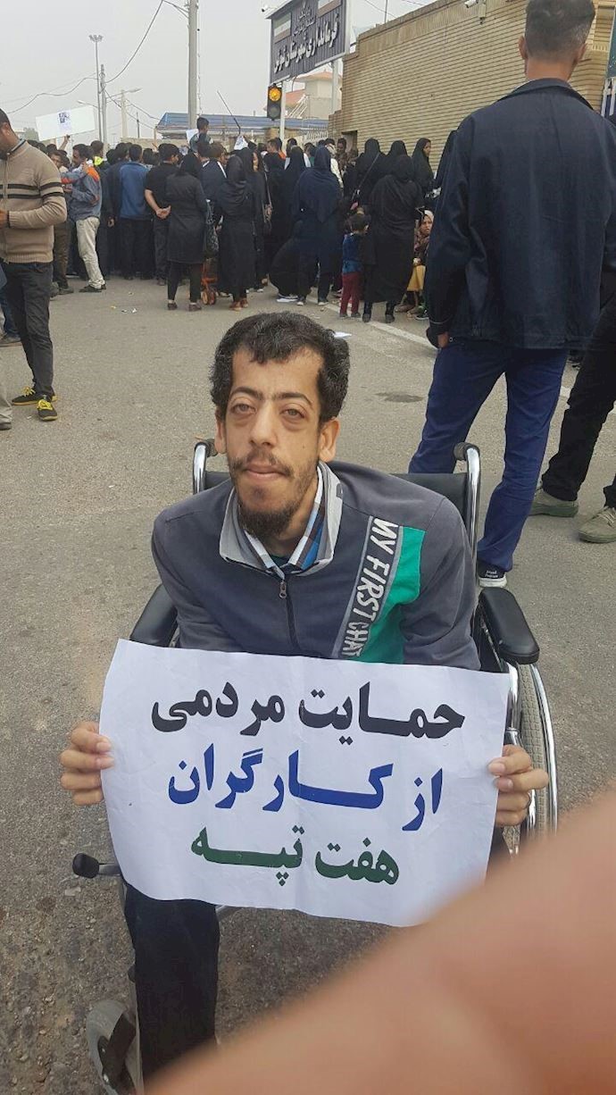 The son of a workers holds a banner in support of the protesters