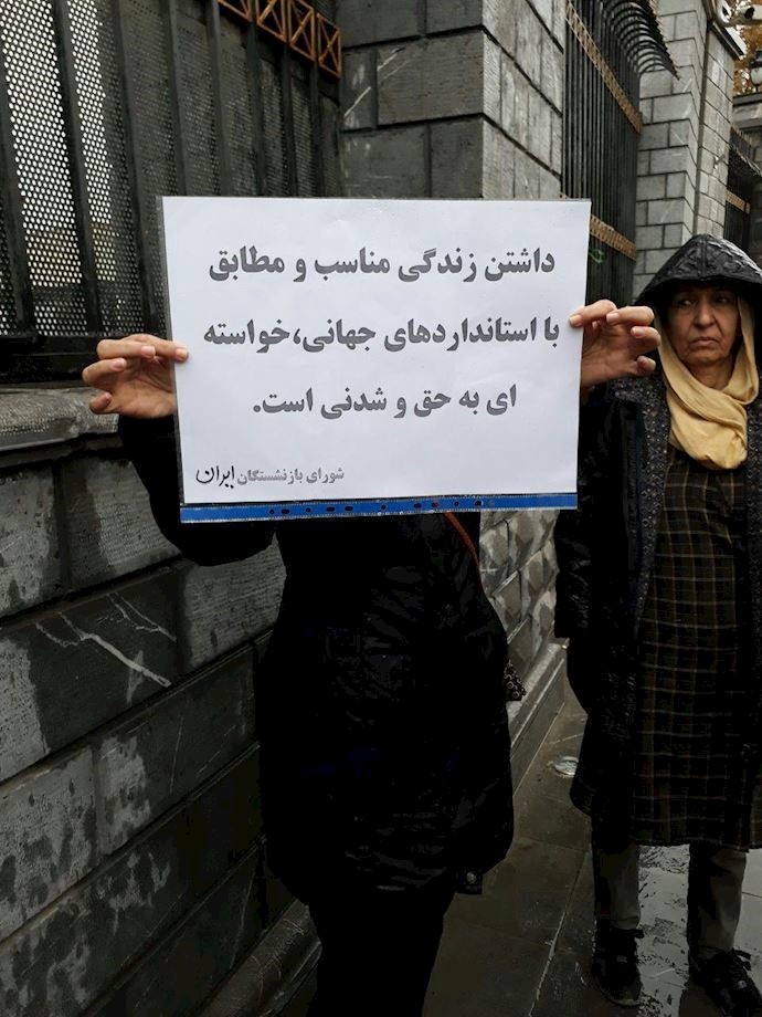 Tehran- a retiree holds a sign saying, “A proper life according to international standards is our feasible just right.”