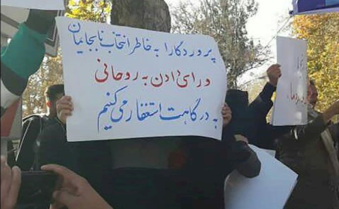 The protesters are raising signs protesting Rouhani’s visit to Shahrud