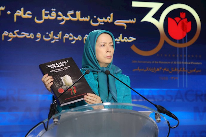 Maryam Rajavi shows the book of the martyrs of the 1988 massacre of pol. prisoners in Iran