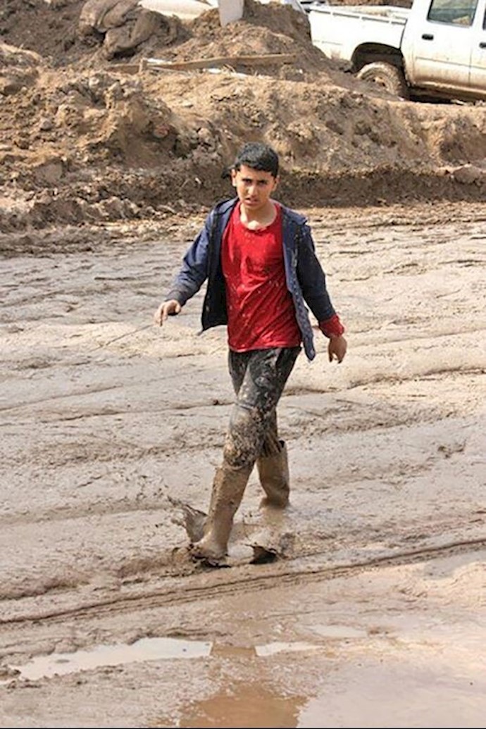 Picture of a boy in mud up to his knees in Pol Dokhtar (Lorestan Province - Western Iran)
