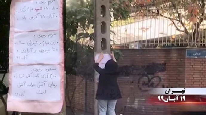 A member of the MEK Resistance Units installs anti-regime slogans in Tehran reading, ““In memory of the 1500 martyrs of the great uprising of the Iranian people,” and “This is an uprising until victory and freedom.”