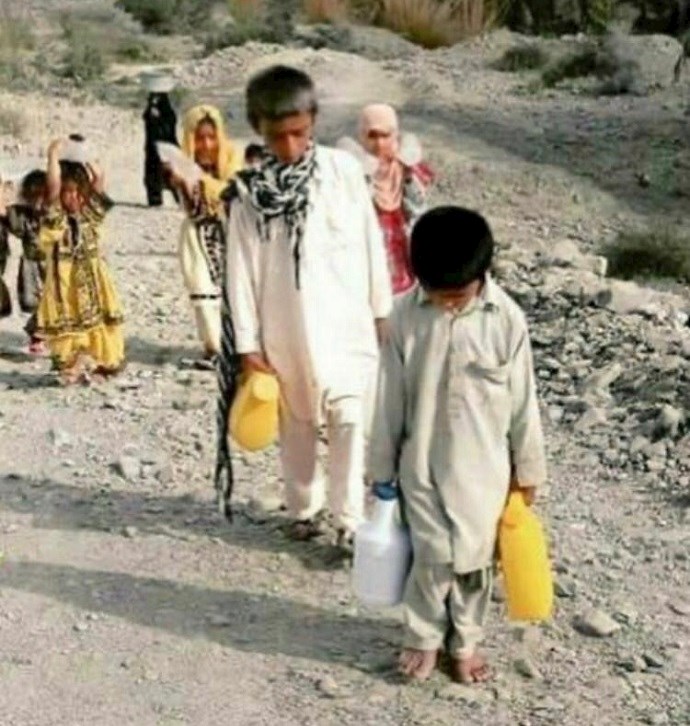 Barefoot children in Sistan & Baluchistan province, southeast Iran, are seen fetching water instead of playing or studying